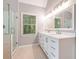 Bathroom featuring tiled floors, a glass shower, and an elegant dual sink vanity at 6895 Old Fox Trl, Stone Mountain, GA 30087