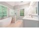 Bright bathroom with a modern soaking tub, glass shower, and dual vanity sinks at 6895 Old Fox Trl, Stone Mountain, GA 30087