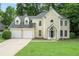 Charming two-story home with a two-car garage, well-manicured lawn, and mature trees at 6895 Old Fox Trl, Stone Mountain, GA 30087