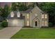 Charming two-story home with a two-car garage, well-manicured lawn, and mature trees at 6895 Old Fox Trl, Stone Mountain, GA 30087