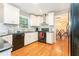 Modern kitchen with white cabinets, hardwood floors, and black appliances at 6895 Old Fox Trl, Stone Mountain, GA 30087