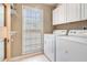 Functional laundry room featuring a washer, dryer, shelving, and ample natural light from a window at 6895 Old Fox Trl, Stone Mountain, GA 30087