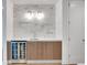 Stylish bar area with marble backsplash, a mini fridge, modern lighting, and wood cabinetry next to a white door at 867 Peachtree Ne St # 202, Atlanta, GA 30308