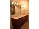 Modern bathroom with wood vanity, granite countertop, and a large framed mirror at 867 Peachtree Ne St # 202, Atlanta, GA 30308
