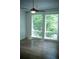 Bright bedroom featuring hardwood floors, a modern ceiling fan, and large windows overlooking lush greenery at 867 Peachtree Ne St # 202, Atlanta, GA 30308