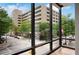 Stunning city view from the condo's large window, showing Peachtree Street and surrounding buildings on a bright, sunny day at 867 Peachtree Ne St # 202, Atlanta, GA 30308