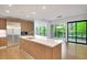 Modern kitchen featuring stainless steel appliances, light wood cabinets, a center island, and a sliding glass doors to the outside at 867 Peachtree Ne St # 202, Atlanta, GA 30308