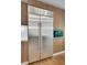 Gourmet kitchen boasts a stainless steel refrigerator, custom cabinetry, and wood flooring at 867 Peachtree Ne St # 202, Atlanta, GA 30308