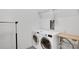 A clean and organized laundry room featuring modern washer and dryer units with wire rack shelving above at 867 Peachtree Ne St # 202, Atlanta, GA 30308