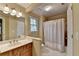 Bathroom with a white sink, oak vanity, shower/tub with a white curtain, and white tile flooring at 1885 Milfield Cir, Snellville, GA 30078