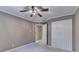 Carpeted bedroom featuring a ceiling fan, closet doors, and neutral painted walls at 1885 Milfield Cir, Snellville, GA 30078
