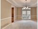 Inviting dining room with chair railing, modern lighting, and a large window offering a pleasant atmosphere at 1885 Milfield Cir, Snellville, GA 30078