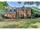 Beautiful two-story brick home with a lush green lawn and mature trees in a well-maintained neighborhood at 1885 Milfield Cir, Snellville, GA 30078