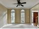 Light-filled living space featuring carpet, arched windows, and a view into the foyer with staircase at 1885 Milfield Cir, Snellville, GA 30078
