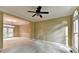 Spacious living room with plush carpeting, a ceiling fan, and large windows providing ample natural light at 1885 Milfield Cir, Snellville, GA 30078