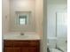 Bathroom with wooden vanity, white sink, mirror, and toilet with white tiled shower at 2499 Shiloh Dr, Decatur, GA 30034