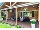 Spacious covered porch featuring stained wood ceiling, hanging string lights, seating, and potted plants at 3843 Lake Se Dr, Smyrna, GA 30082