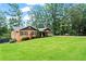 Charming brick home with a well-manicured lawn, mature trees, and inviting front porch at 3843 Lake Se Dr, Smyrna, GA 30082