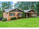 Charming brick home featuring a spacious covered porch with a gable and a large yard at 3843 Lake Se Dr, Smyrna, GA 30082