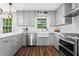 Updated kitchen boasts stainless steel appliances, grey cabinetry, and a farmhouse sink at 3843 Lake Se Dr, Smyrna, GA 30082