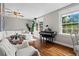 Bright living room features a comfortable white sofa, a piano, and hardwood floors at 3843 Lake Se Dr, Smyrna, GA 30082