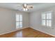 Cozy bedroom with hardwood floors, ceiling fan and bright, shuttered windows at 402 Johannah Sw Pl, Lilburn, GA 30047