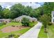 Spacious home exterior with a long driveway, lush lawn, and mature trees for privacy at 402 Johannah Sw Pl, Lilburn, GA 30047