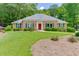 Charming brick home with a well-maintained front yard, mature trees, and colorful landscaping at 402 Johannah Sw Pl, Lilburn, GA 30047