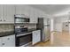 Eat-in kitchen with stainless appliances, granite counters, and tiled backsplash at 402 Johannah Sw Pl, Lilburn, GA 30047