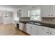 Kitchen showcasing stainless dishwasher, dual sinks, granite counters, and white cabinetry at 402 Johannah Sw Pl, Lilburn, GA 30047
