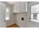 Bright laundry room with washer/dryer hookups, storage cabinets, and a window for natural light at 402 Johannah Sw Pl, Lilburn, GA 30047