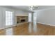 Open living room featuring a brick fireplace, hardwood floors, ceiling fan, and natural light at 402 Johannah Sw Pl, Lilburn, GA 30047