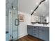 Stylish bathroom featuring double vanity, framed mirror, and sleek glass shower with white hexagon tile at 622 Seminole Ne Ave, Atlanta, GA 30307