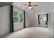Bright, carpeted bedroom with multiple windows, ceiling fan, and gray curtains at 622 Seminole Ne Ave, Atlanta, GA 30307