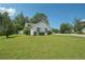 Front yard view of a house with green lawn and mature trees on a sunny day at 742 Redland Dr, Jonesboro, GA 30238