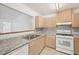 Bright kitchen featuring light wood cabinets, granite countertops, and modern white appliances at 742 Redland Dr, Jonesboro, GA 30238