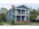 Charming two-story home with a blue exterior, white columns, and inviting front porches on both levels at 117 Joseph E Lowery Nw Blvd, Atlanta, GA 30314