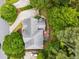An aerial view of a beautiful home with a large roof, green trees, driveway, and a deck with a red umbrella at 2425 Hamptons Psge, Alpharetta, GA 30005