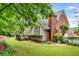 Backyard featuring a lush lawn, wooden deck, and mature trees at 2425 Hamptons Psge, Alpharetta, GA 30005
