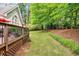 Backyard featuring a lush lawn, wooden deck, and mature trees at 2425 Hamptons Psge, Alpharetta, GA 30005