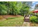 Backyard featuring a lush lawn, wooden deck, and mature trees at 2425 Hamptons Psge, Alpharetta, GA 30005