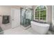 Spa-like bathroom featuring a soaking tub, a glass enclosed shower, and tiled floors at 2425 Hamptons Psge, Alpharetta, GA 30005