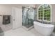 Bright bathroom featuring a soaking tub and a glass-enclosed shower at 2425 Hamptons Psge, Alpharetta, GA 30005