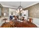 Formal dining room featuring hardwood floors, wainscoting and an elegant light fixture at 2425 Hamptons Psge, Alpharetta, GA 30005