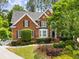 Charming two-story brick home featuring a well-manicured lawn and mature landscaping at 2425 Hamptons Psge, Alpharetta, GA 30005