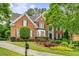 Stately brick home with manicured landscaping, mature trees, and a welcoming front entrance at 2425 Hamptons Psge, Alpharetta, GA 30005