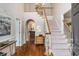 Grand foyer with a staircase, hardwood floors, and an arched doorway at 2425 Hamptons Psge, Alpharetta, GA 30005