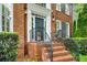 Welcoming brick home entrance with manicured shrubs, and decorative lights at 2425 Hamptons Psge, Alpharetta, GA 30005