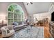 Cozy living room featuring a fireplace, large window, and open floor plan to the kitchen at 2425 Hamptons Psge, Alpharetta, GA 30005