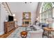 Inviting living room featuring a stone fireplace, staircase, and large window at 2425 Hamptons Psge, Alpharetta, GA 30005